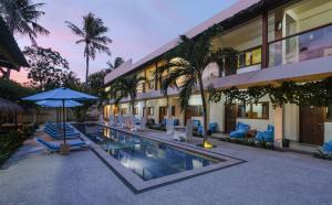 吉利特拉旺安旺安尼尔瓦纳酒店的享有带游泳池、椅子和遮阳伞的度假村外部景色
