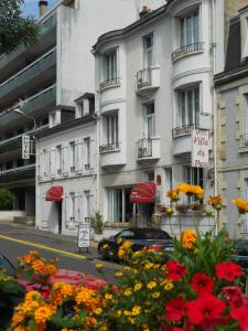 讷韦尔公园别墅酒店的鲜花盛开的建筑前的停车位