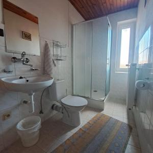 新里斯拉娜塔莎私人酒店的浴室配有卫生间、盥洗盆和淋浴。