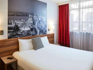 利物浦利物浦市中心阿德吉奥公寓式酒店的一间卧室配有一张大床和红色窗帘