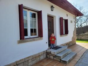 米拉弗洛迪拉希El Robledal - Miraflores de la Sierra的站在房子外的小男孩