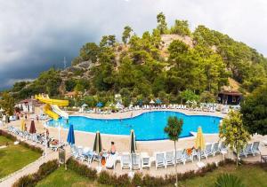 安塔利亚MIRAMOR HOTEL & Spa - ULTRA ALL INCLUSIVE的度假村内的大型游泳池配有椅子和遮阳伞