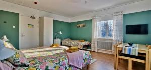 VindelnKronlund Kursgård的一间卧室配有两张床、一张桌子和一台电视。