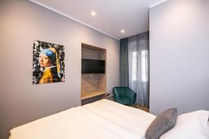 里耶卡Teatro Suite & Rooms的一间卧室配有一张床、镜子和电视