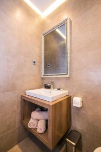 里耶卡Teatro Suite & Rooms的浴室配有盥洗盆、镜子和毛巾