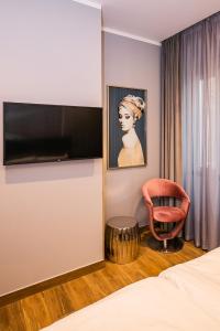 里耶卡Teatro Suite & Rooms的配有床、椅子和电视的房间