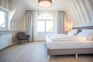 奥斯赛拜-屈隆斯博恩屈隆斯伯恩维尔四季酒店的一间卧室设有两张床、一把椅子和一个窗户。