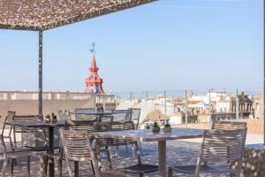 塞维利亚Hotel Macià Sevilla Kubb的餐厅屋顶上一排桌椅