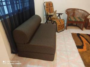 Simpang RenggamR&R HOMESTAY的客厅里设有一张棕色沙发,配有椅子