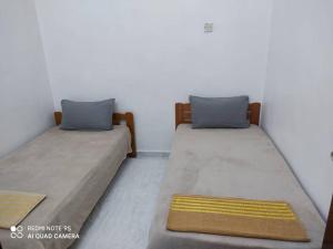 Simpang RenggamR&R HOMESTAY的两张睡床彼此相邻,位于一个房间里