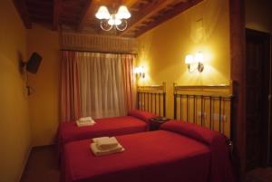 Villarmentero de Campos拉卡松纳德多尼亚佩特拉酒店的一间房间,房间内设有两张红色的床