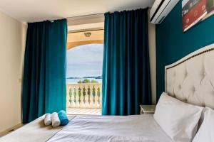 索佐波尔Touristic Complex Hacienda Beach Apartments Sozopol的一间卧室配有床和蓝色窗帘的窗户