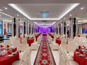 荣市Muong Thanh Thanh Nien Vinh的宴会厅配有红色和白色的桌椅