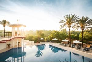 卡拉塞雷娜ROBINSON Cala Serena的棕榈树酒店的一个游泳池