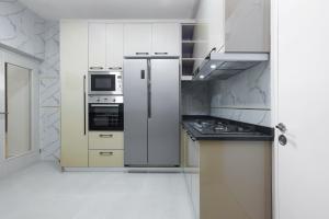 阿布贾BKT Cribs - Apartments & Suites的厨房配有白色橱柜和不锈钢冰箱