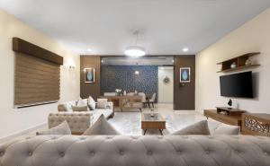阿布贾BKT Cribs - Apartments & Suites的客厅配有两张沙发和一台电视机