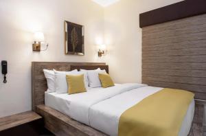 阿布贾BKT Cribs - Apartments & Suites的一间卧室配有一张带白色和黄色枕头的大床