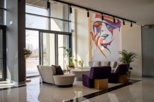 贝尔格莱德Calisi Hotel的大堂设有椅子和墙上的绘画作品