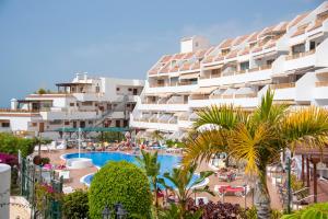 阿德耶Luxury Apartaments in Costa Adeje, Los Geranois的享有带游泳池和棕榈树的度假村景色