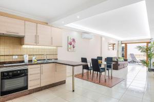 阿德耶Luxury Apartaments in Costa Adeje, Los Geranois的厨房以及带桌椅的起居室。