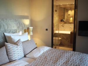 哥本哈根Hypernym Hotel & Suites的一间卧室配有一张床,浴室设有淋浴。
