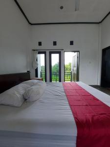 BalianBalian One的卧室配有一张大白色床和红色毯子