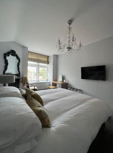 朗里奇The Dog Inn的卧室配有一张带吊灯的大型白色床。