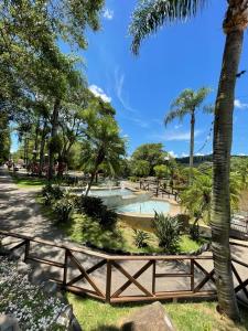 皮拉图巴Casa das Bromélias- Com Quiosque em meio à natureza!的一个带游泳池、树木和围栏的公园