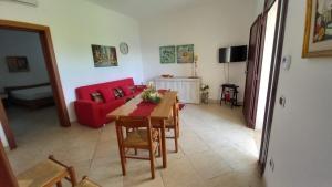 托雷拉皮罗Casa Domenica的客厅配有桌子和红色沙发