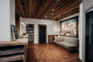 埃尔瓦尔德Alpenappartements Cristall的客厅配有沙发和墙上的绘画