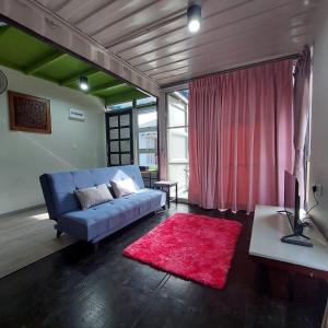 MerlimauLaman Sakinah Merlimau的客厅配有蓝色的沙发和红色地毯。