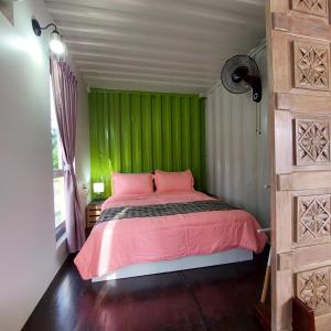 MerlimauLaman Sakinah Merlimau的绿色卧室设有粉红色的床和窗户