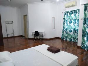 士姑来Sapporo Homestay的白色的客房配有一张床和椅子