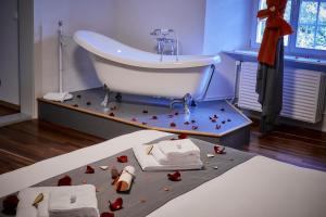 BellelayAuberge de Bellelay的浴室设有水槽和位于地板上的玫瑰浴缸。