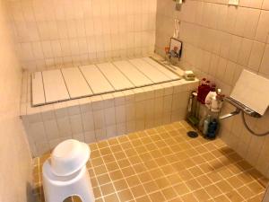 岛田Kappo Ryokan Uoichi的一间带卫生间的浴室和瓷砖地板。