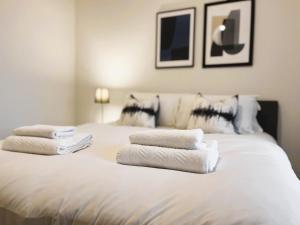 曼彻斯特Brand new modern 1 bed apartment near Old Trafford Stadium的白色的床,上面有毛巾