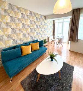 布达佩斯Nova Apartments的客厅配有蓝色的沙发和桌子