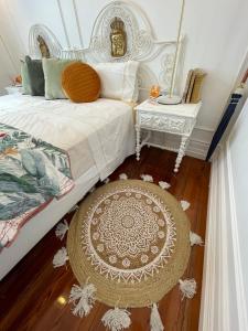 蓬塔德尔加达Open Door Loft的一间卧室配有一张床、一张桌子和一张地毯。