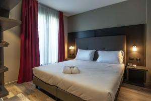 马拉内罗马拉内罗宫酒店的卧室配有一张带红色窗帘的大型白色床