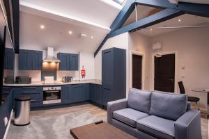 利物浦城堡系列14库克街公寓的厨房配有蓝色橱柜和沙发