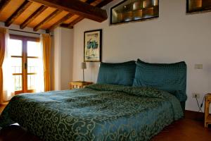 卡斯德尔诺沃贝拉登卡Centro Ippico Della Berardenga的一间卧室配有一张带绿色棉被的床