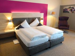 卡斯特劳恩伯格斯塔特酒店的一间卧室配有一张大床和一把椅子