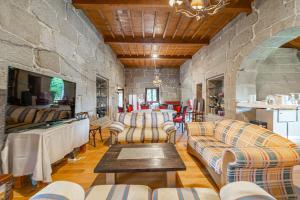 AmoeiroCasa Rural Pazo San Damian的带沙发和石墙的客厅