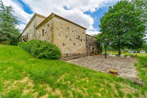 AmoeiroCasa Rural Pazo San Damian的享有带庭院的石头建筑的外部景色