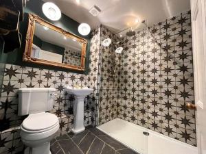 Blue AnchorBlue Anchor House - Seaview, Hot Tub Apartments的浴室配有卫生间、镜子和浴缸。