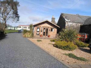 牛顿斯图尔特Castlewigg holiday park Whithorn 2 bed caravan的前面有车道的小房子