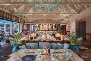 古斯塔维亚Le Barthélemy Hotel & Spa的一间配备有蓝色沙发和桌子的用餐室