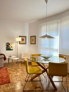 CastandielloAngliru 1 Suite的一间设有玻璃桌和黄色椅子的用餐室