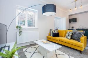 格里姆斯比Coppergate Mews Grimsby No.3 - 2 bed, 2 bath, ground floor apartment的客厅配有黄色的沙发和桌子