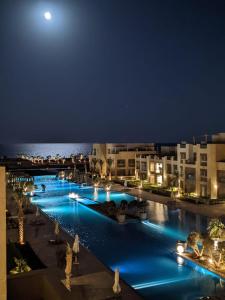 赫尔格达Mangroovy Ritzy, Cerulean appartement by the pool的夜间游泳池,月亮在后方
